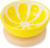 A yellow ceramic bowl shaped like a lemon slice sits on a round wooden board. Produktbild-Vorschau