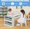 Two young children are using a wooden activity table and chair set in a playroom setting. Produktbild-Vorschau