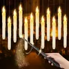 A hand holding a magic wand, with a trail of glitter, in front of a row of hanging LED candles. Produktbild-Vorschau