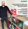 A man standing next to a shelf unit filled with various items, including boxes and storage containers. Produktbild-Vorschau