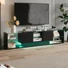 A modern black TV lowboard with glass shelves and RGB lighting, featuring a television and decorative items. Produktbild-Vorschau