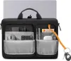 A black laptop bag with multiple compartments, showing various tech accessories inside, with a laptop partially visible behind it. Produktbild-Vorschau