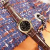 A close-up shot of a Casio watch with a brown leather strap, resting on a textured blue and orange fabric. Produktbild-Vorschau