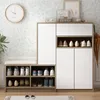 A shoe cabinet with a bench seat in a room with floral wallpaper. Produktbild-Vorschau