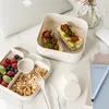 A lunchbox and its contents are arranged on a desk next to a laptop and a notebook. Podgląd zdjęcia produktu