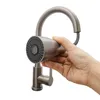 A hand is holding a kitchen faucet sprayer head. Podgląd zdjęcia produktu