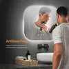 A man is shaving in front of a lighted mirror in a bathroom. Podgląd zdjęcia produktu