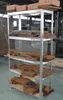 A metal shelving unit filled with wooden planks and some cardboard boxes on top. Náhled obrázku produktu
