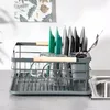 A dish drying rack with glasses and cutlery is placed next to a sink. Produktbild-Vorschau