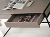 A close-up view of a desk with an open drawer containing magazines and a phone on top. Voir les images du produit
