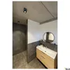 A modern bathroom with a shower area and a vanity with a sink and mirror. Produktbild-Vorschau