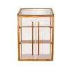 A mini greenhouse with wooden frame and clear polycarbonate panels, featuring two shelves and double doors. Voir les images du produit