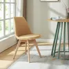 A yellow upholstered chair sits next to a round table with a vase and a book on it, near a window with natural light. Náhled obrázku produktu