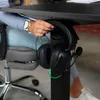A person is hanging headphones on a desk. Náhled obrázku produktu