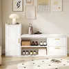 A white shoe cabinet with a padded bench seat and drawers, displayed in a room with artwork on the wall and a rug on the floor. Produktbild-Vorschau