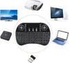 A collage of various electronic devices including a projector, TV, computer monitor, laptop, media box, wireless keyboard, and a USB dongle, arranged around a central wireless keyboard. Anteprima dell’immagine prodotto