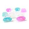 Several baby pacifiers and teethers in blue and pink colors are arranged on a white background. Produktbild-Vorschau