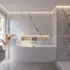 A modern, minimalist bathroom featuring a large bathtub with marble-effect walls and integrated lighting. Produktbild-Vorschau