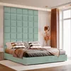 A bed with a mint green upholstered headboard and platform, styled with pillows and a throw blanket. Anteprima dell’immagine prodotto