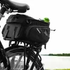 A black bicycle bag mounted on the rear rack of a bicycle, with a green water bottle on top. The background is a blurred view of water and greenery. Anteprima dell’immagine prodotto