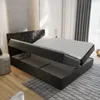 A bed with its storage compartment open, showing the mattress and the storage space underneath. Produktbild-Vorschau