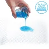 A hand is pouring blue liquid from a glass onto a white absorbent pad, demonstrating its absorbency. A circular icon with water droplets and layers is in the upper right corner. Náhľad obrázku produktu