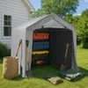 A portable storage shed filled with toolboxes and gardening tools, situated on a grassy lawn next to a house. Náhled obrázku produktu