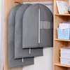 Garment bags hanging on a rod in a closet next to shelves with storage boxes and books. Produktbild-Vorschau