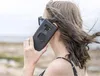 A woman is holding a phone to her ear, outdoors. Produktbild-Vorschau