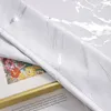A close-up view of a white curtain with a silver marble pattern, partially covering a framed picture of flowers. Produktbild-Vorschau