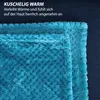 A close-up of a teal-colored fluffy blanket with a textured pattern, layered over itself, with dark blue background. Náhľad obrázku produktu