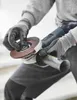 A person wearing work gloves is holding an angle grinder and a metal pipe. Produktbild-Vorschau