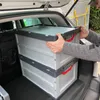 A person is placing foldable storage boxes into the trunk of a car. Produktbild-Vorschau