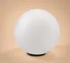 A white spherical lamp with a black base on a light peach background. Produktbild-Vorschau