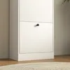 A close-up view of a white cabinet with a black knob on one of its doors. Produktbild-Vorschau