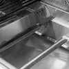 Close-up view of the interior of a gas grill, showing the burners and heat deflectors. Produktbild-Vorschau