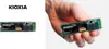 A split image showing a Kioxia SSD on the left against a white background, and on the right, a hand holding the same SSD. Podgląd zdjęcia produktu