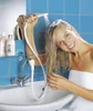 A woman is washing her hair in a sink using a handheld shower attachment. Produktbild-Vorschau