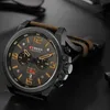 A close-up shot of a men's wristwatch with a leather strap, displayed on a dark surface. Produktbild-Vorschau