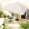 An outdoor patio scene with a table, chairs, and a large umbrella. Produktbild-Vorschau