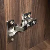 A close-up view of a cabinet hinge attached to a wooden surface. Produktbild-Vorschau