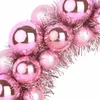A close-up view of pink Christmas ornaments intertwined with tinsel. Voir les images du produit