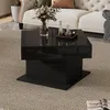A modern living room scene featuring a black high-gloss coffee table with a vase of flowers and decorative bottles on top. Produktbild-Vorschau