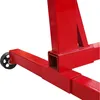 A close-up of the red metal base of a motor stand with a wheel. Náhľad obrázku produktu