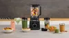 A kitchen counter with a blender and various ingredients and prepared items. Produktbild-Vorschau
