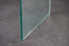 A close-up shot of a glass table edge on a dark gray surface. Produktbild-Vorschau
