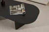 A dark oval coffee table with a magazine and a dark brown vase on it, placed on a textured rug. Voir les images du produit
