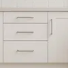 Close-up of kitchen cabinet drawers and a cabinet door with handles. Produktbild-Vorschau
