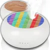 Two diffusers are shown, one with a wood-grain top and another with a rainbow-striped top, with steam rising from the latter. Podgląd zdjęcia produktu