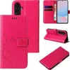 A collage of images showing a pink floral butterfly flip phone case from different angles, including one with a phone inserted and cards/cash in the wallet section. Produktbild-Vorschau